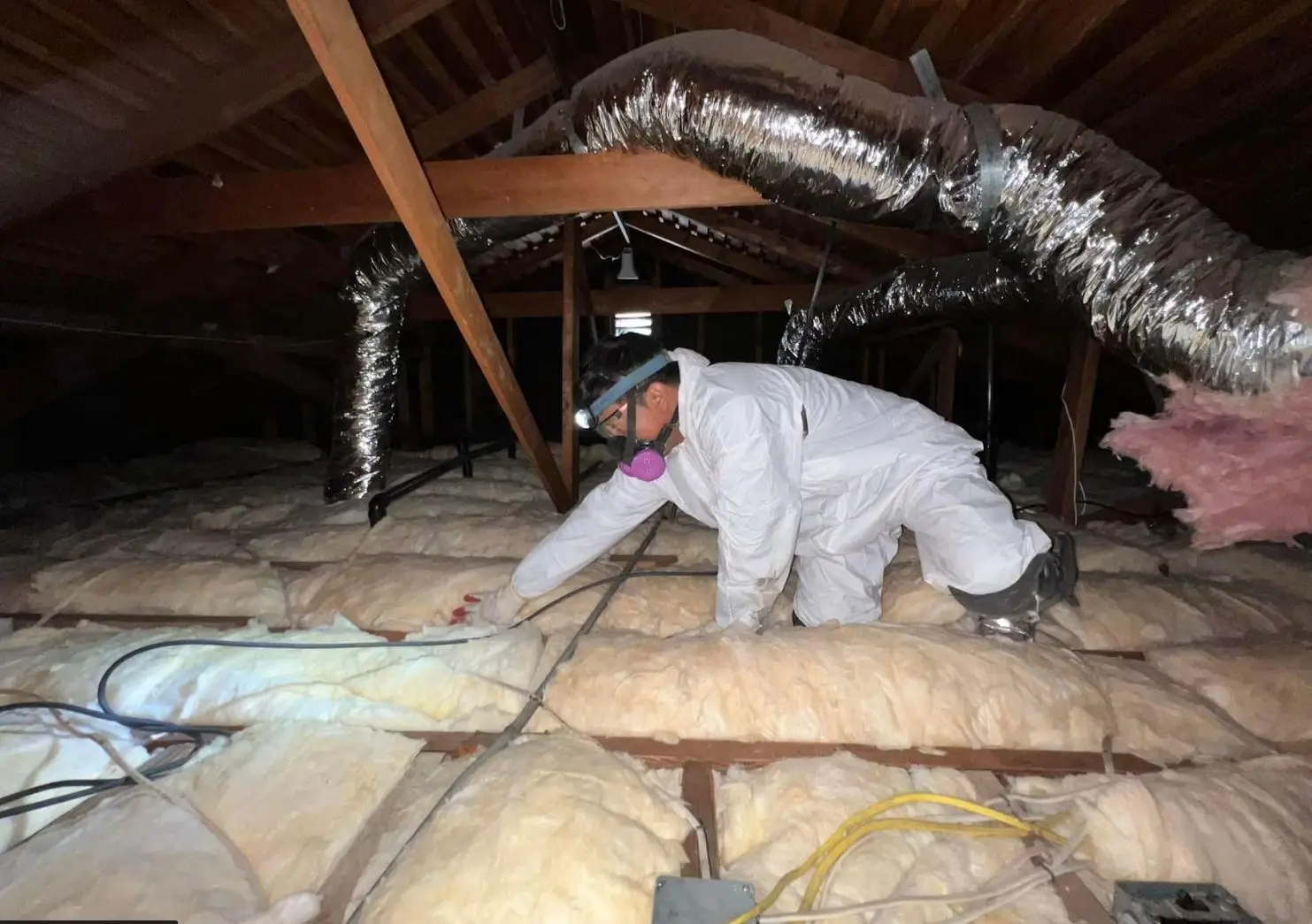 Insulation technician installing attic insulation in a Southern California home
