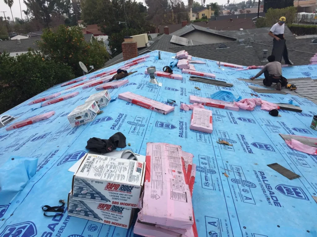 roofing crew installing asphalt shingles over synthetic underlayment on a Los Angeles home