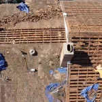 aerial view of a roof tear-off with old shingles stripped back to bare skip sheathing on a Los Angeles home