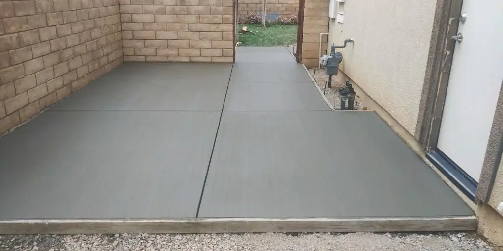New concrete slab along the side of a house next to a block wall