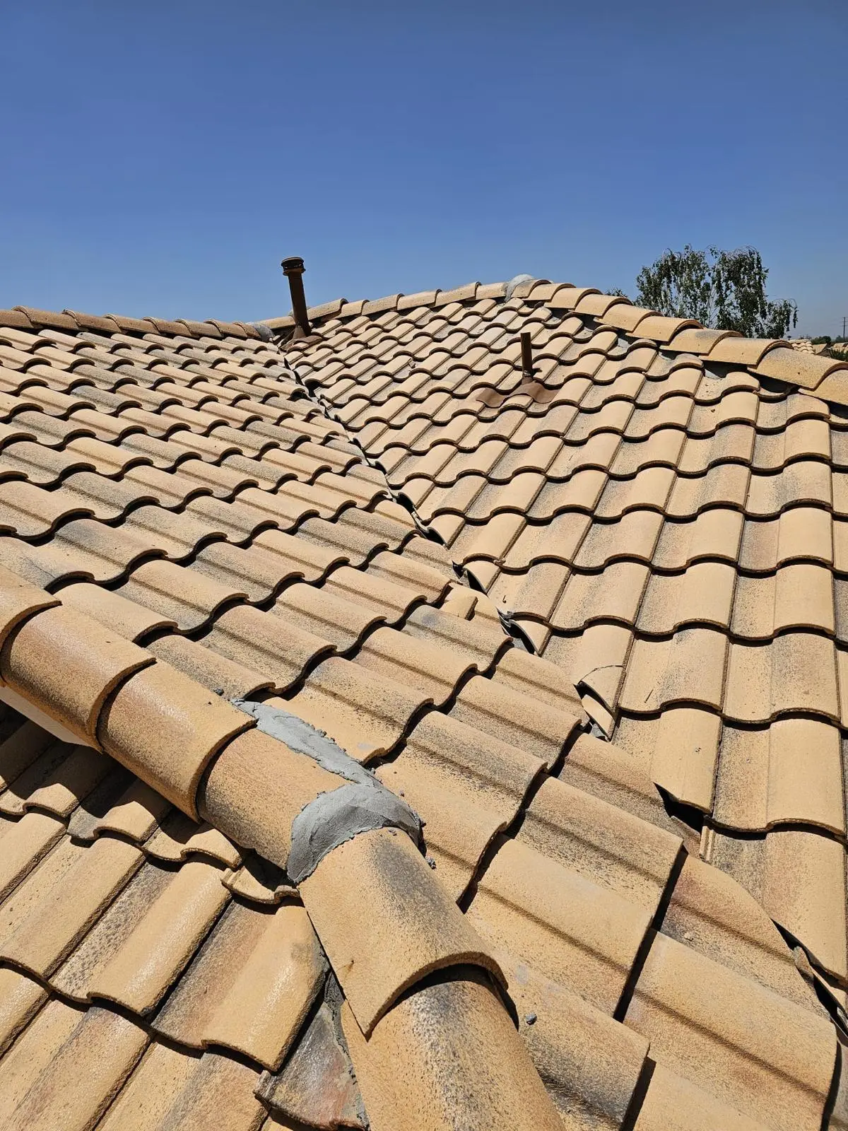 cracked and broken clay barrel tiles on an aging Southern California roof