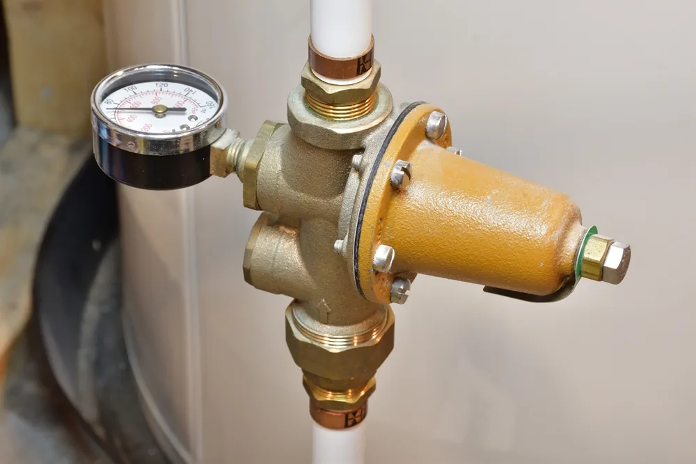 brass water pressure regulating valve with a pressure gauge on the main supply line